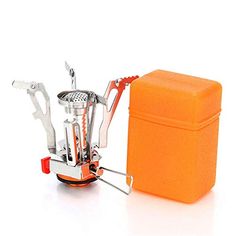 an orange box with utensils in it sitting next to a small stove top