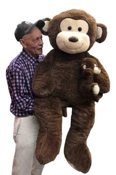 a man standing next to a giant teddy bear in the shape of a monkey on his back