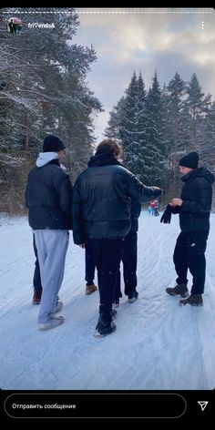 four people are standing in the snow on skis and one person is pointing at something