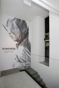 a white room with black and white graphics on the wall next to glass railings