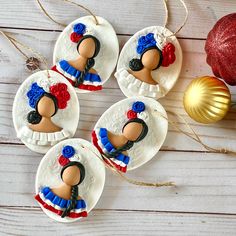 four decorated cookies on white plates with red, white and blue decorations in the shape of women