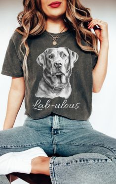 a woman sitting on top of a pair of jeans wearing a dog t - shirt