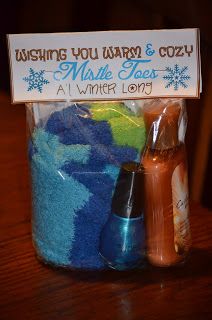 a jar filled with blue towels and other items on top of a wooden table next to a sign that says wishing you warm & cozy