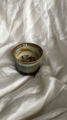 a small bowl sitting on top of a white sheet