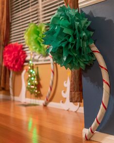 a christmas tree made out of paper on top of a wooden floor next to a window