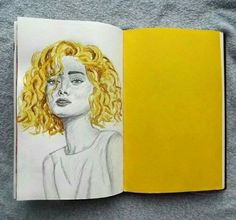 an open book with a drawing of a woman's face and yellow hair on it