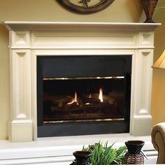 a living room with a fire place in the center and two vases on the table