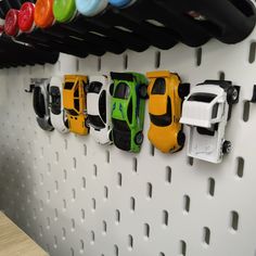 several toy cars are lined up on the wall