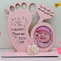 a pink frame with a baby's feet and a flower on top of it