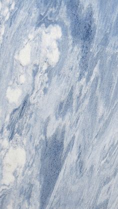 a blue and white marble surface with clouds in the sky above it, as seen from an airplane