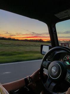 the driver is driving down the road at sunset