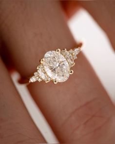 a woman's hand with a three stone ring on top of her finger,