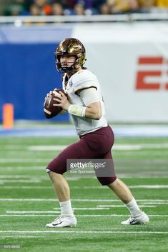 a football player holding a ball in his hands on the field during a game stock photo