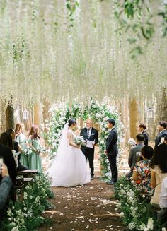 the bride and groom are getting married in front of an outdoor ceremony