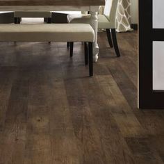 a dining room with wood flooring and white chairs