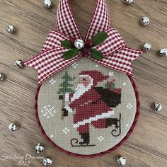 a cross stitch christmas ornament hanging on a table