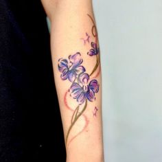 a woman's arm with purple flowers on it