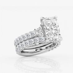 an engagement ring set with a princess cut diamond in the center and side stones on each band