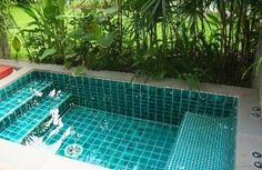 an empty swimming pool surrounded by greenery