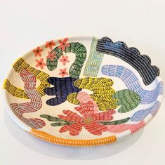 a plate with flowers painted on it sitting on a table