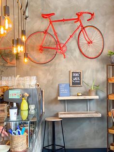 a bike mounted to the wall in a store with shelves and stools next to it