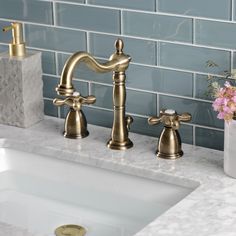 two faucets are sitting next to each other on the counter top in this bathroom