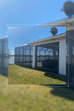 an image of the outside of a building with grass and water in front of it