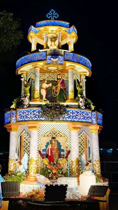 an elaborately decorated building with statues on it's sides and lights in the background