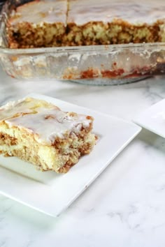 a piece of cake sitting on top of a white plate next to a casserole dish