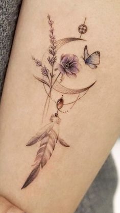 a woman's leg with a tattoo on it and flowers in the middle of her thigh