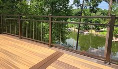 a wooden deck overlooking a lake and trees