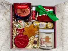 a gift box filled with cookies, candy and other holiday treats for someone to enjoy