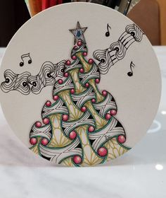 a christmas tree with music notes on it and pencils in the holder next to it