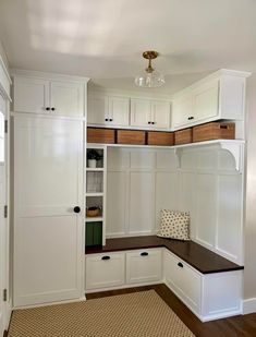 a room with white cupboards and a bench