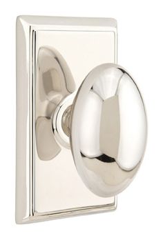 an image of a chrome door handle on a white wall mounted light switch with round knobs