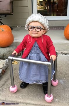 an old woman doll sitting on top of a metal chair