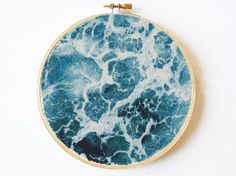 a blue and white marble pattern is shown in an embroidery hoop on a white surface