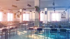 an empty classroom with desks and chairs in the middle, sunlight shining through windows