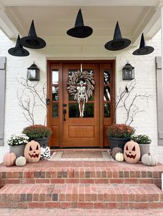 a front porch decorated for halloween with pumpkins and jack - o'- lanterns