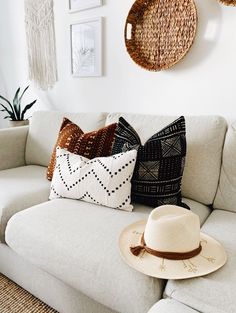 a white couch with pillows and a hat on it