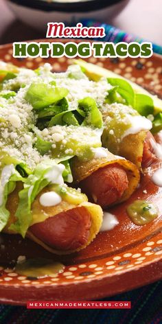 mexican hotdog tacos with lettuce and cheese on a red plate next to a bowl of salsa