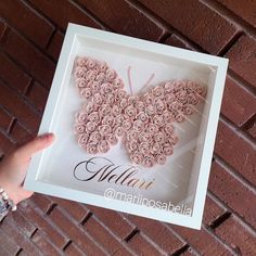 a person holding up a pink rosette butterfly in a white frame with the word mammamoscapella written on it