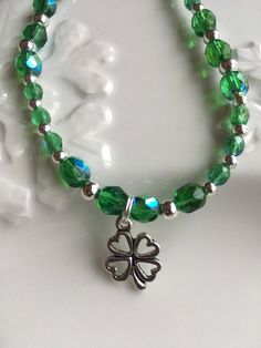 "\"St. Patrick's Day Shamrock Bracelet \" Multi-faceted green with a tint of blue Czech glass beads have been combined with round silver beads to create this beautiful bracelet. It is closed with a silver toned nickel free lobster clasp and a silver extension chain for added length if needed. This bracelet is adjustable from 7.5 - 9-inches and is finished with a silver shamrock charm.  This bracelet would be the perfect St. Patrick's Day gift and would compliment a dressy or casual wardrobe.  Yo Shamrock Bracelet, Shamrock Necklace, Silver Shamrock, 3 Earrings, Glass Bead Bracelet, Green Bracelet, Sterling Silver Bead Bracelet, Multicolor Earrings, Leaf Bracelet