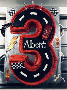 the birthday cake is made to look like a number three with cars and lightning on it