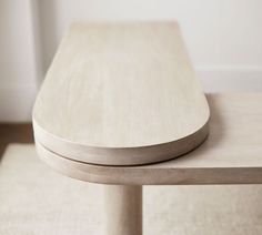 a wooden table sitting on top of a white rug