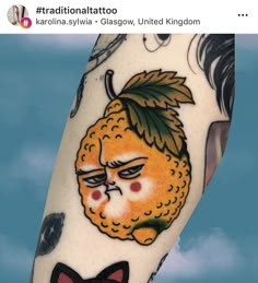 an orange tattoo on the leg of a person with a black bow tie and cat