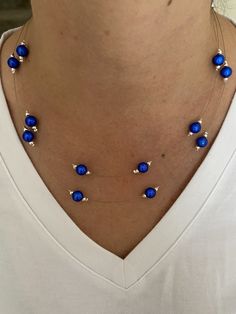 This is a beautiful double strand necklace made with the stunning blue miracle beads.  The necklace is a pretty delicate necklace with a floating bead effect. The beads are 8mm blue miracle beads. These beads are a mesmerising blue which show a 3d effect and stunning shine. Either side of the blue beads there are 2mm silver plated beads which compliment the blue perfectly. The beads are spaced along tiger tail wire. The shortest strand is 45 cm in length and the longest strand is 50 cm in length. The necklace fastens by way of a lobster clasp and ring.  Lead and Nickle free.  The necklace is packaged and wrapped in a pink Sugar and Spice gift box making the perfect and special gift.  Thanks for looking in my shop! Blue Double Strand Beaded Necklace For Gift, Blue Double Strand Necklace With Faceted Beads, Blue Double Strand Necklaces For Party, Blue Double Strand Necklace For Party, Elegant Blue Double Strand Necklace, Blue Double Strand Beaded Necklace With Polished Beads, Blue Double Strand Beaded Pearl Necklace, Blue Double Strand Pearl Necklace Gift, Blue Multi-strand Elegant Beads