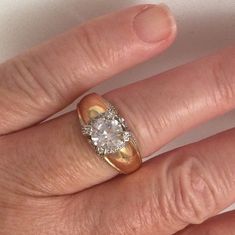 a woman's hand with a gold and diamond ring on top of her finger