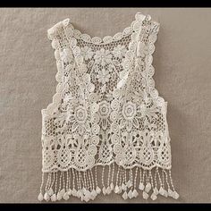 a white top with lace and beads on it