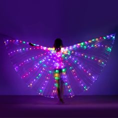 a woman with lights on her wings is standing in front of a purple background,